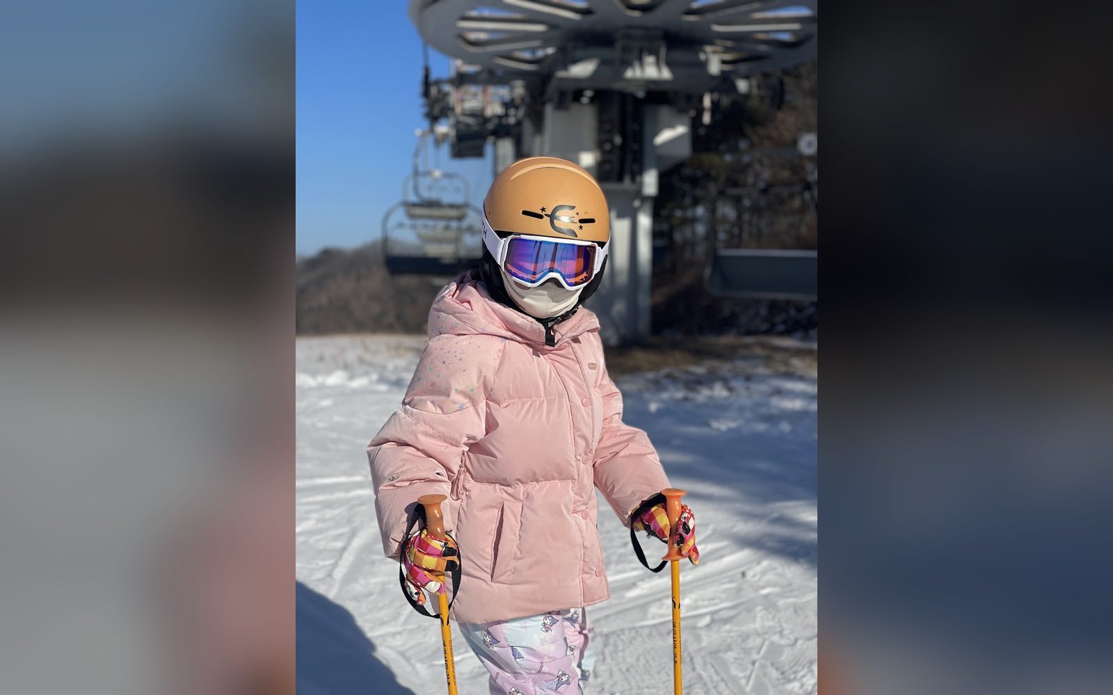 분홍 패딩을 입고 리프트 앞에 선 아이
