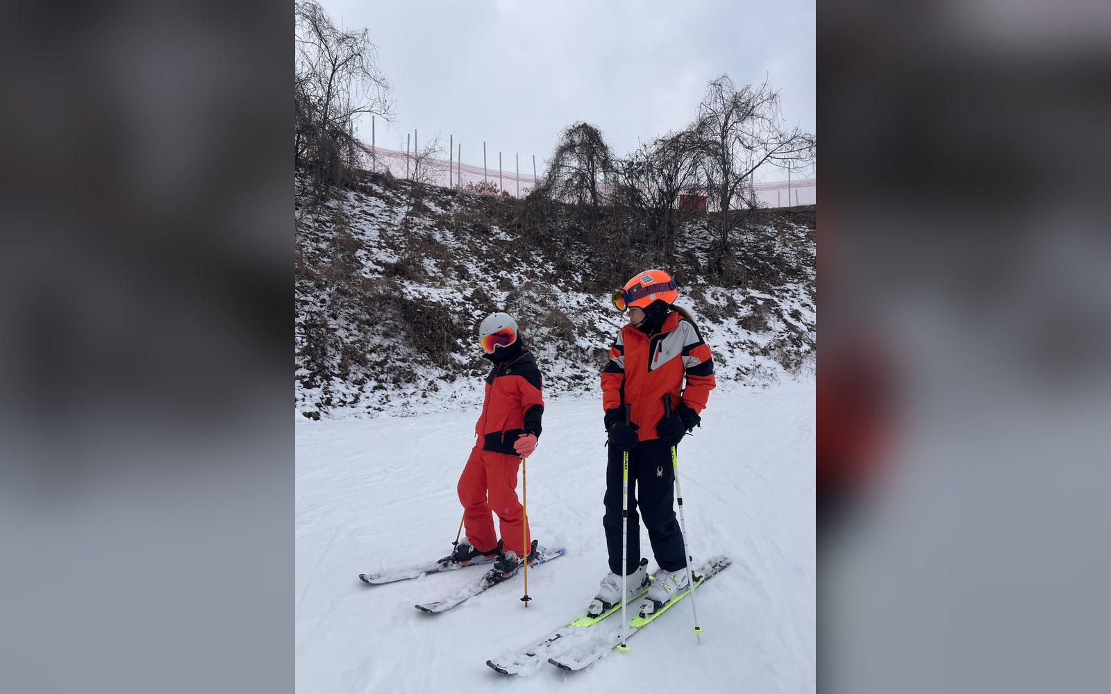 빨간 스키복을 입고 나란히 선 아이 두 명