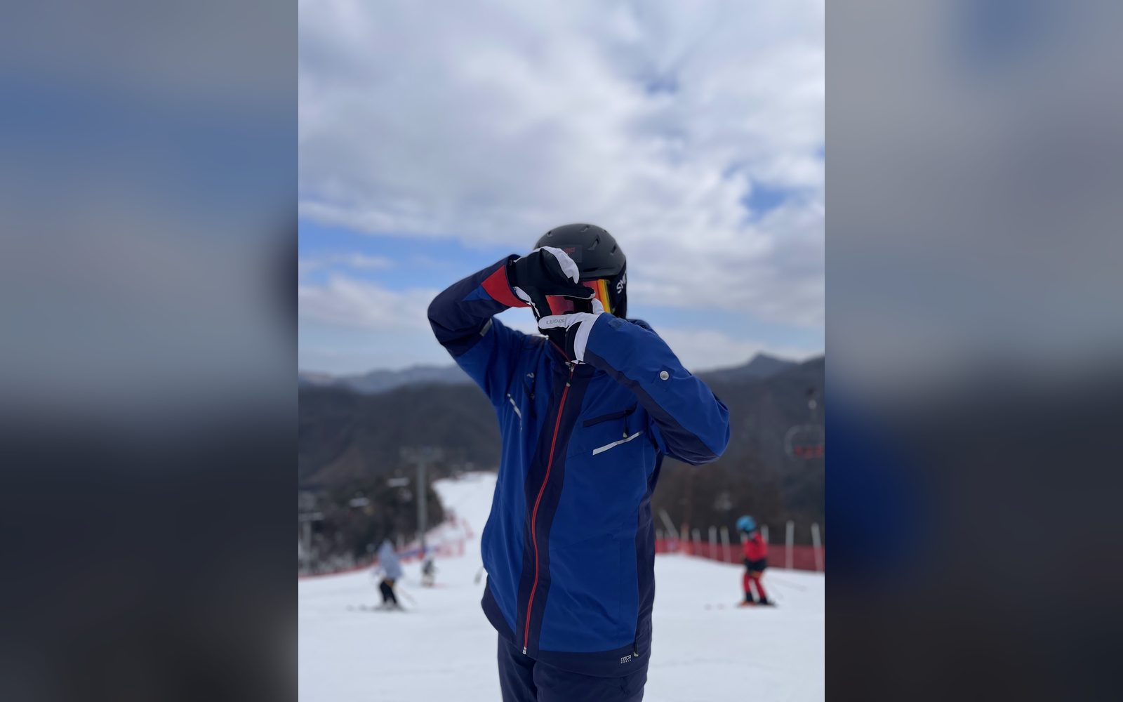 고글을 고쳐 쓰며 슬로프에 선 스키어