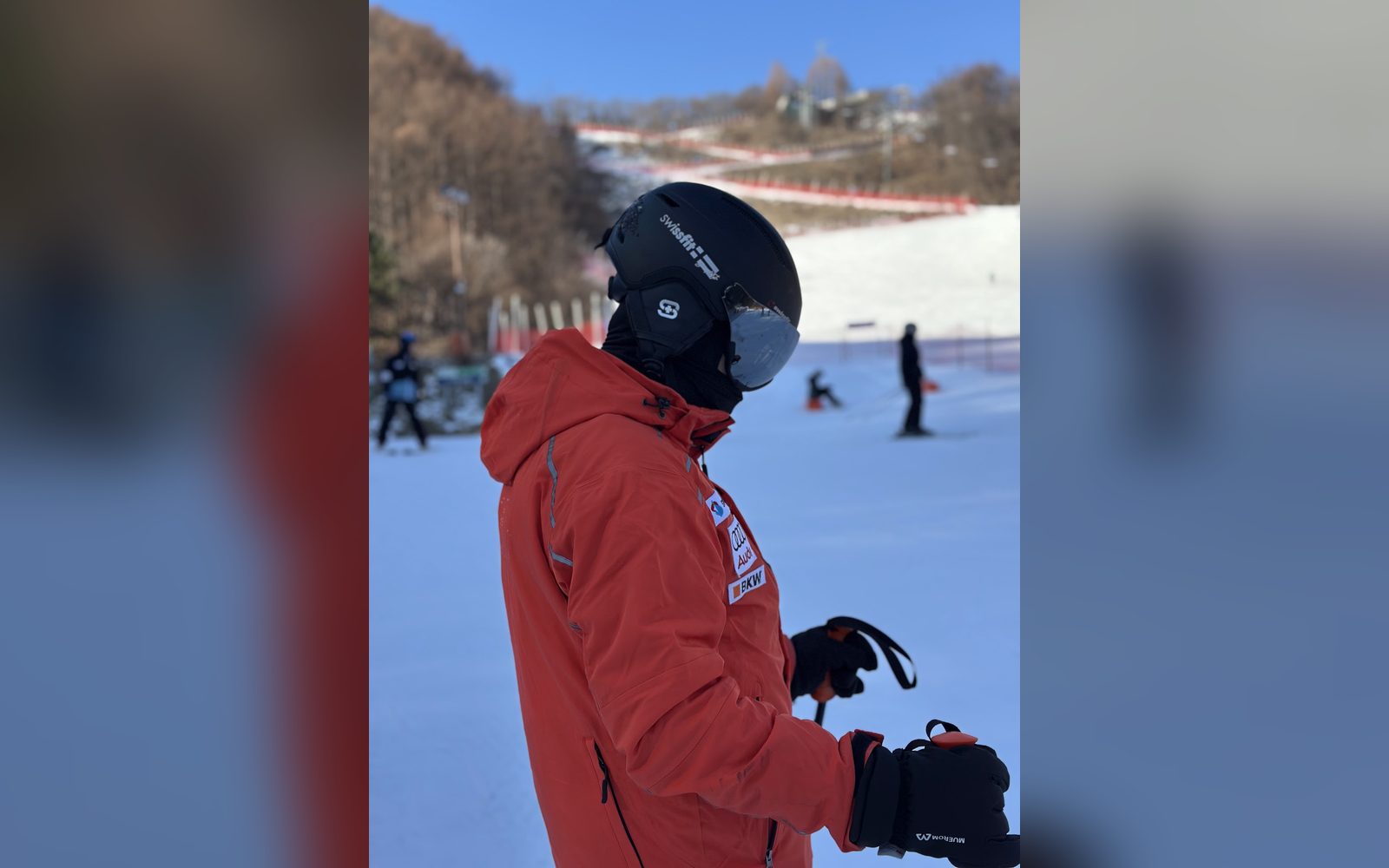 빨간 재킷을 입고 슬로프를 바라보는 지도자