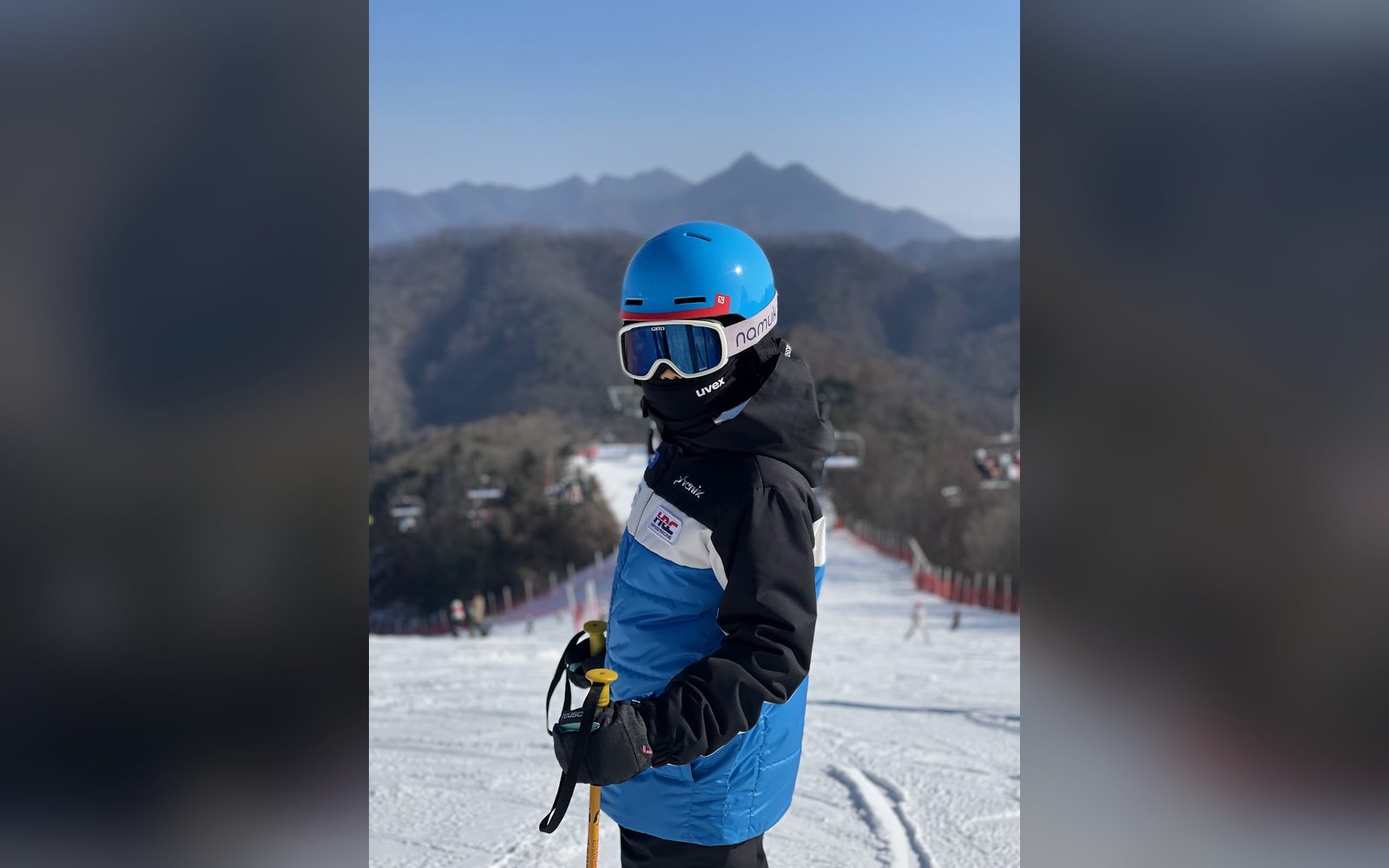 파란 헬멧을 쓰고 산을 등진 아이