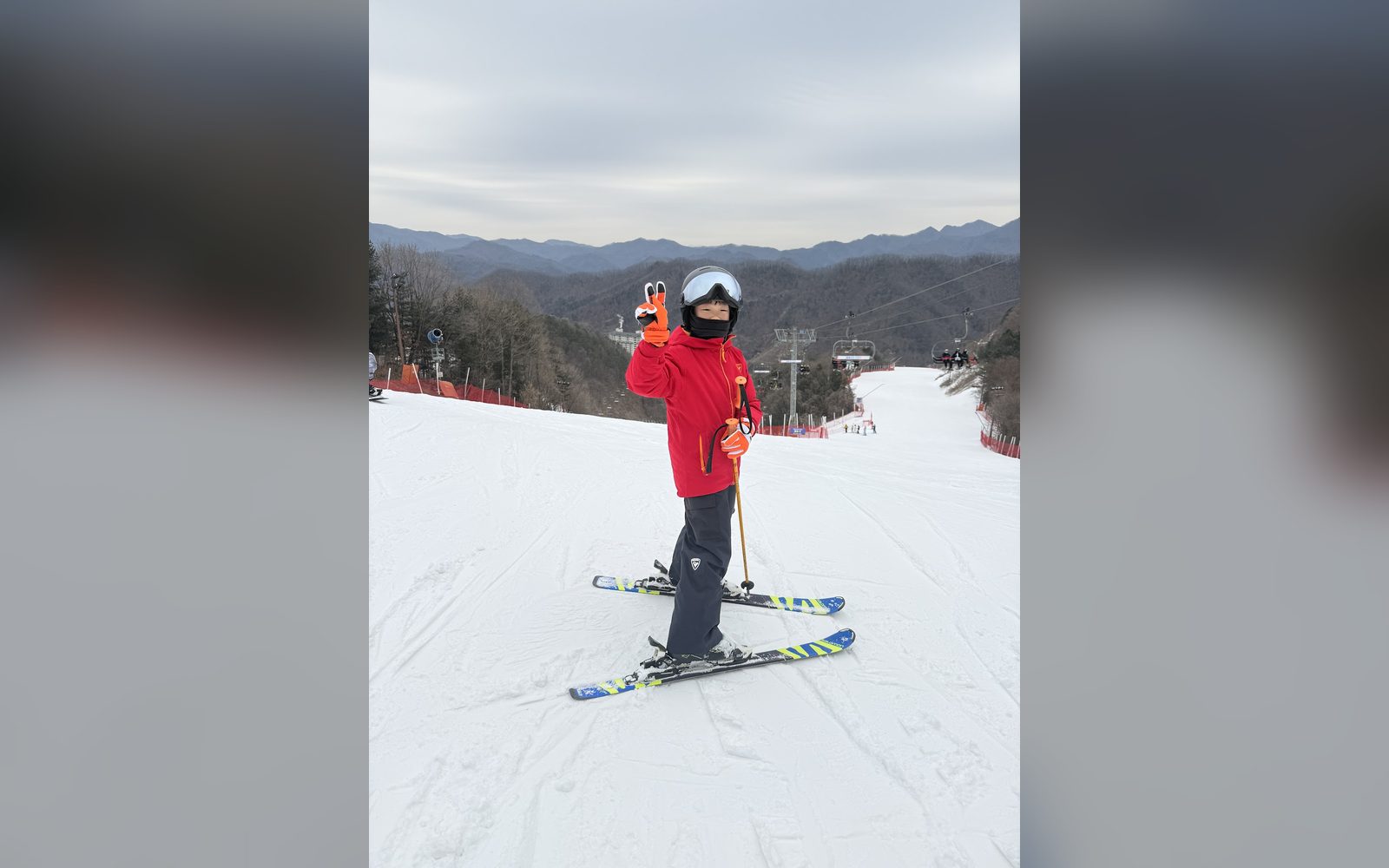 빨간 재킷을 입고 넓은 슬로프에 선 아이