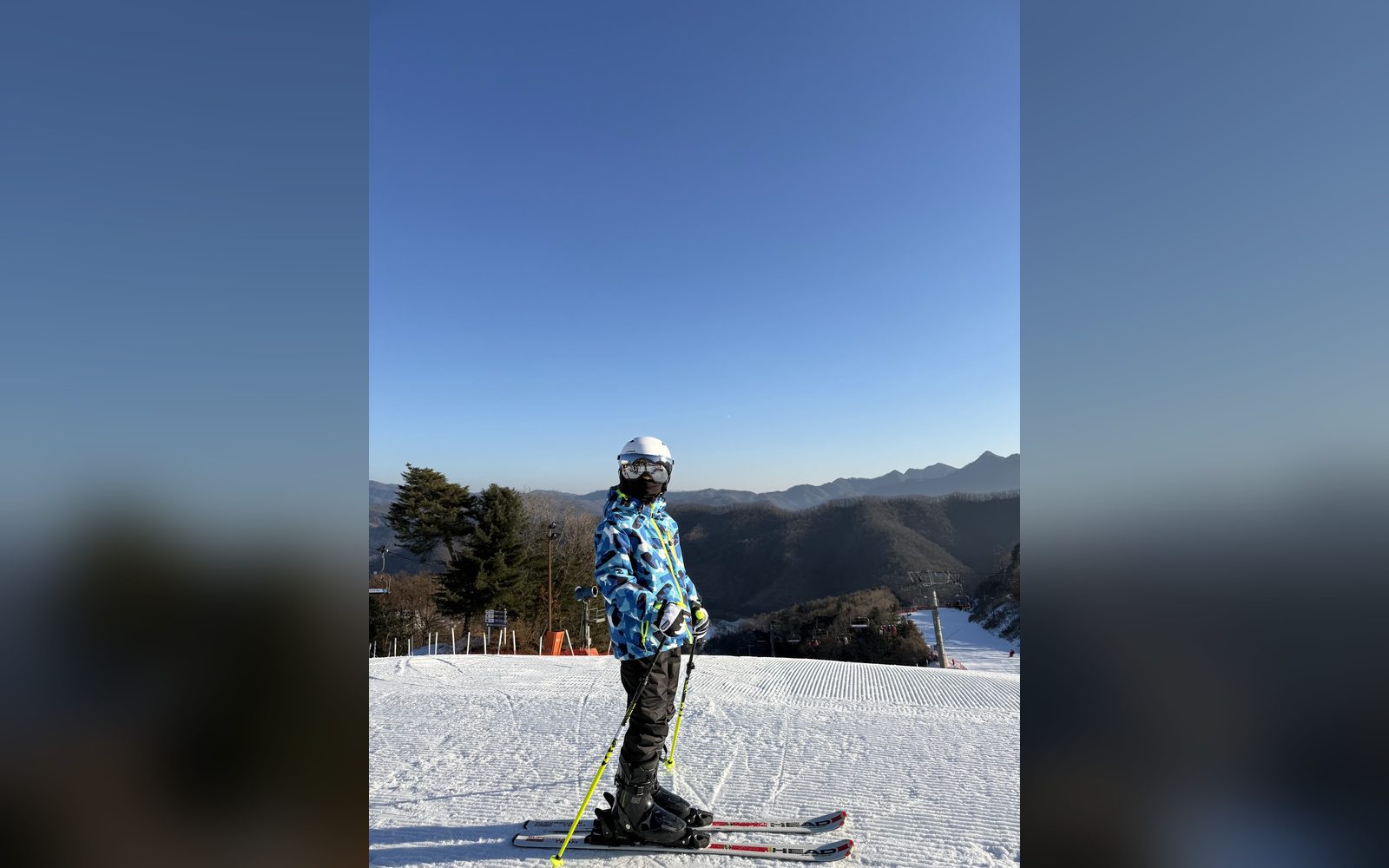 산 정상에서 스키를 신고 선 아이