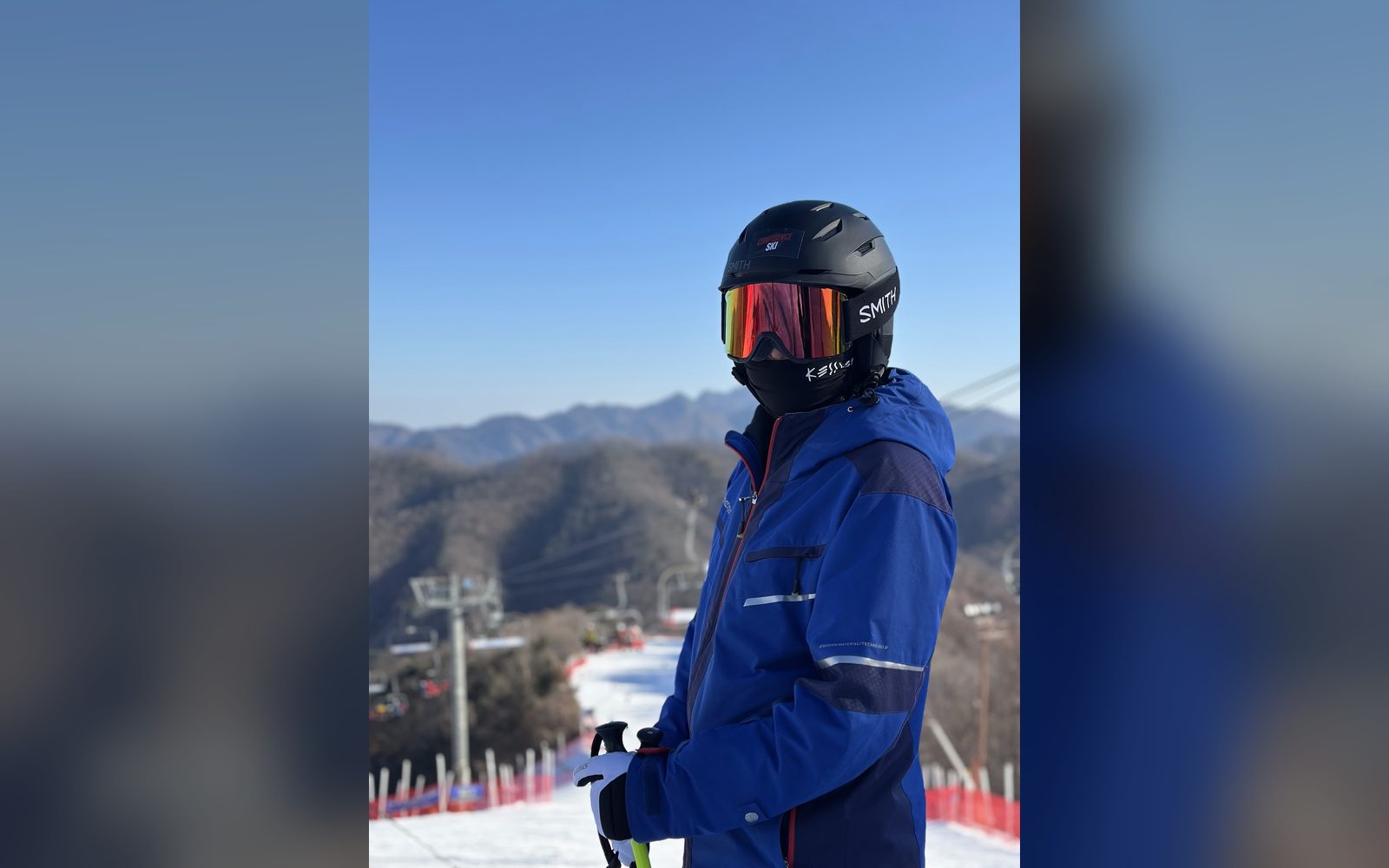 파란 재킷을 입고 리프트 앞에 선 아이