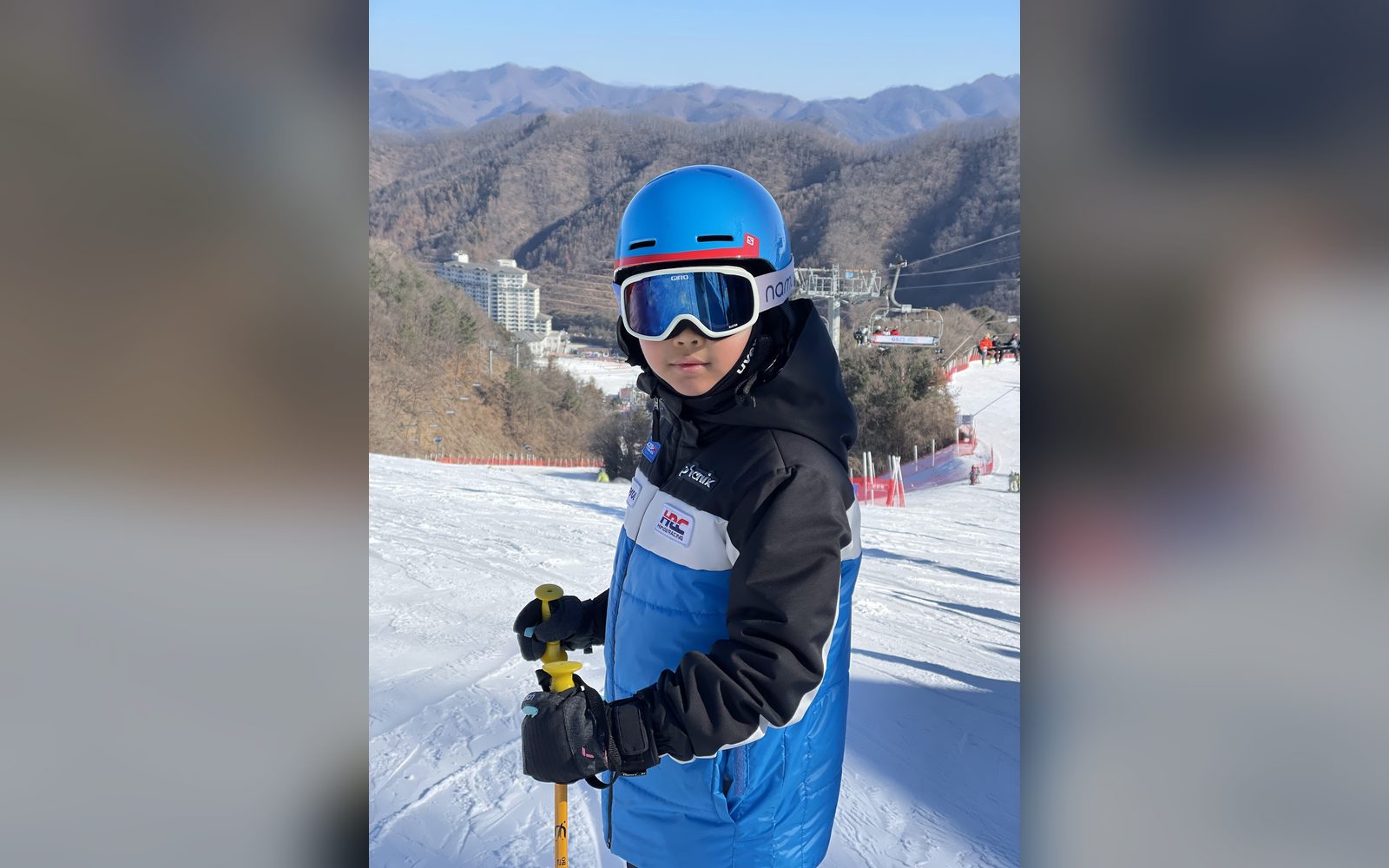 파란 헬멧을 쓰고 산을 등진 아이