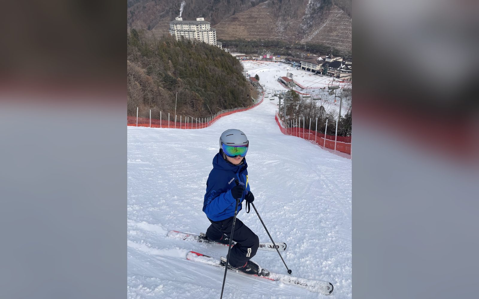 슬로프를 내려오는 파란 재킷의 아이