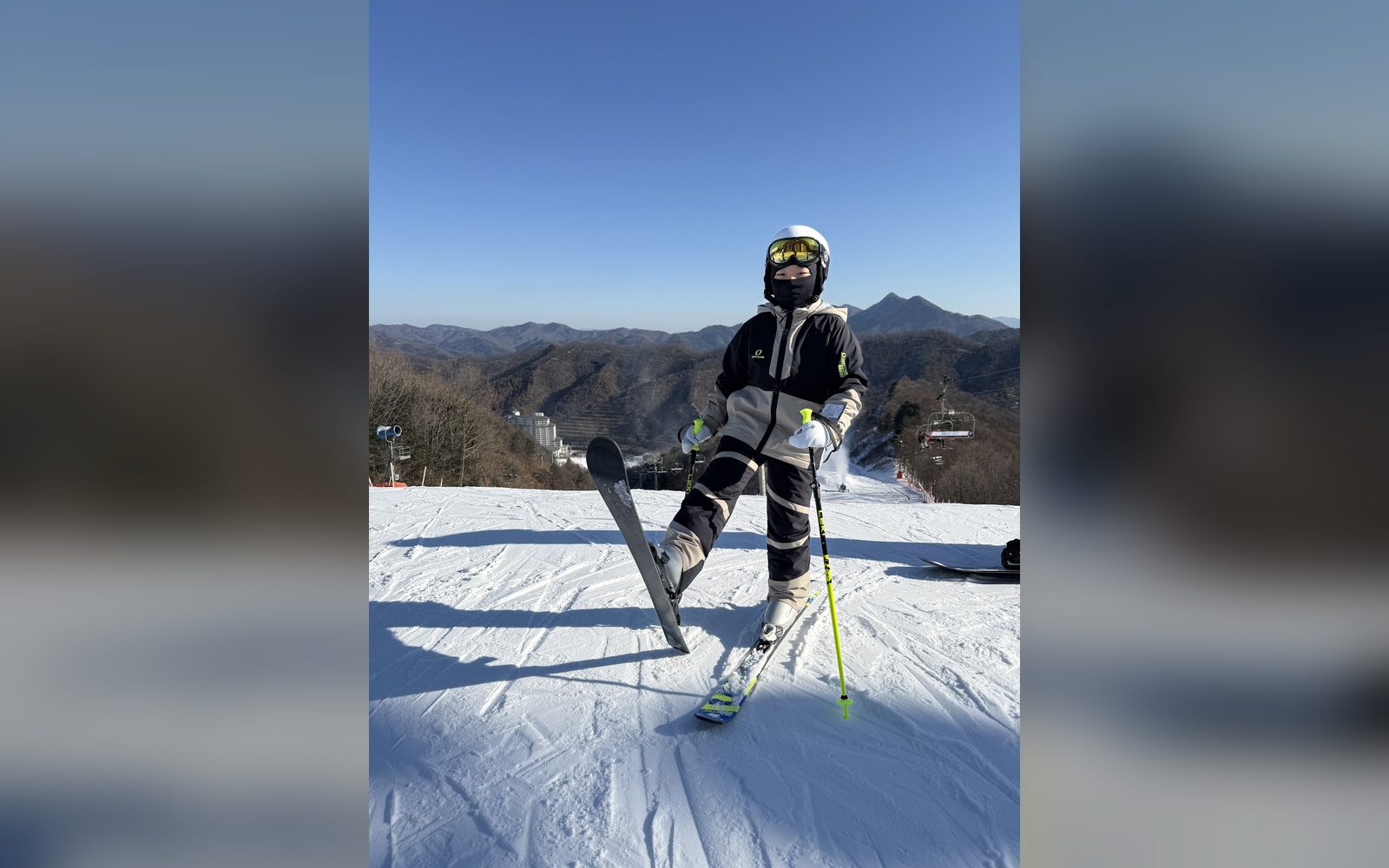 산 정상에서 스키를 들어 올린 아이