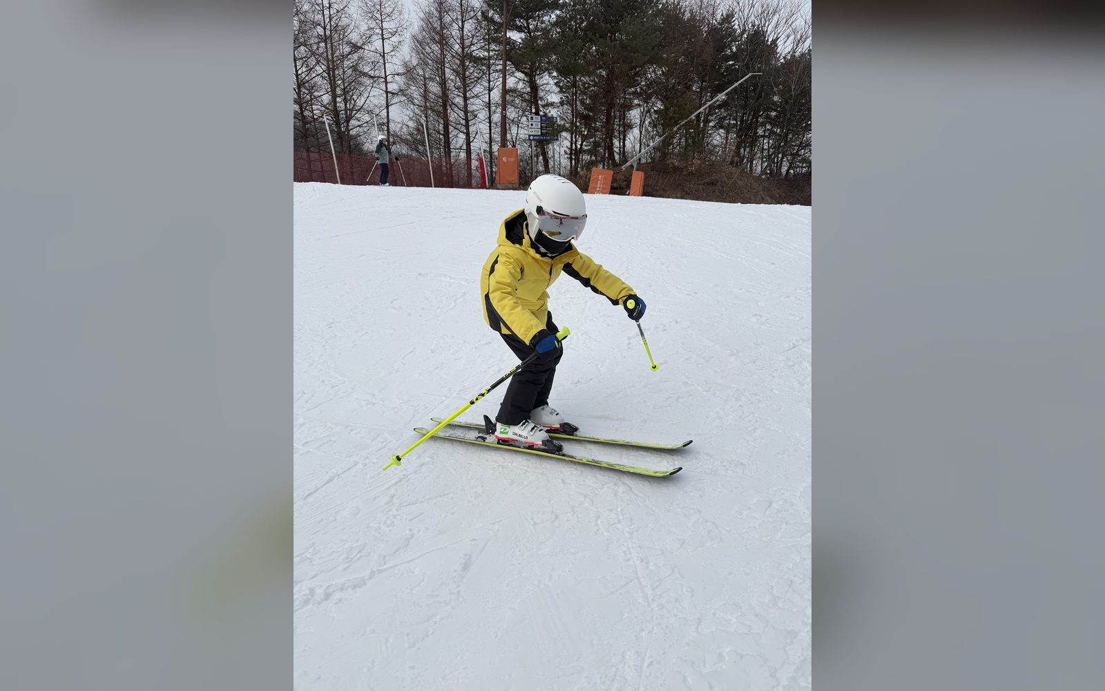 노란 재킷을 입고 턴을 하는 아이
