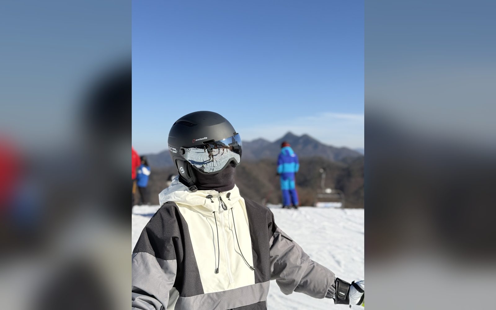 흰 재킷을 입고 헬멧과 고글을 쓴 아이
