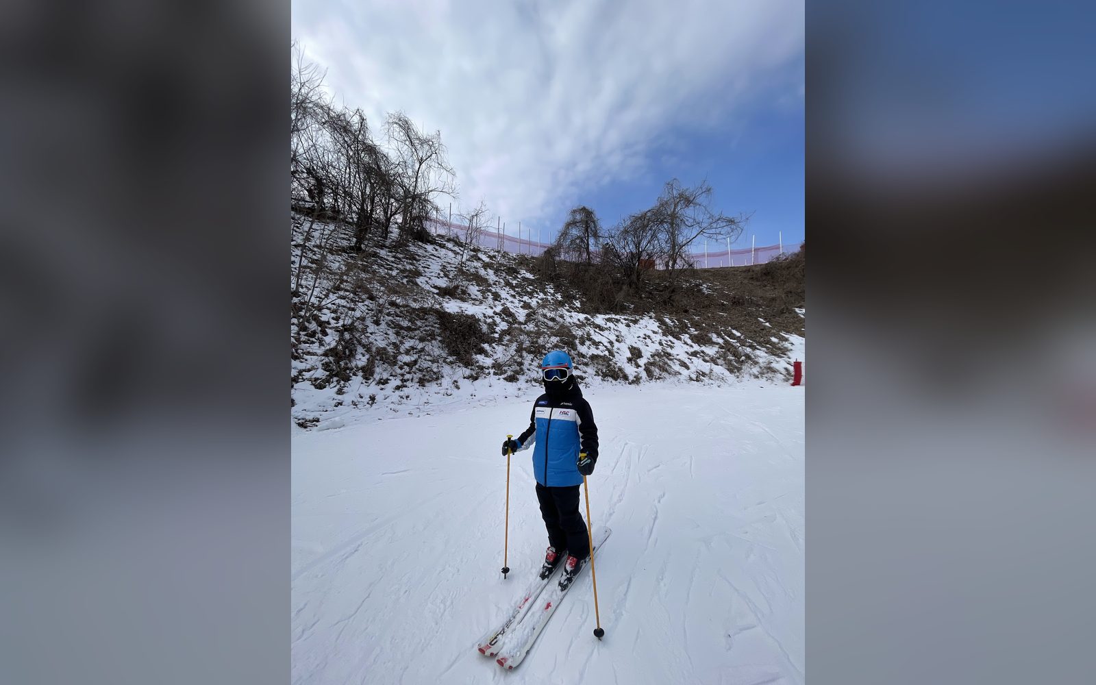 흐린 하늘 아래 슬로프에 선 아이