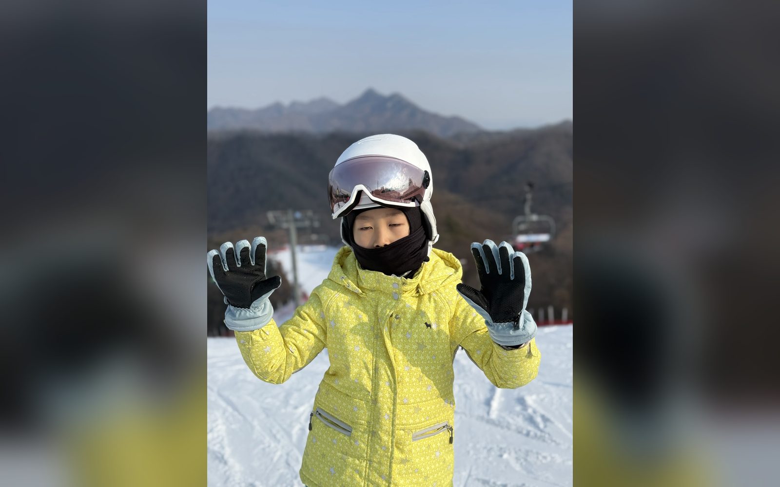 노란 재킷을 입고 두 손을 든 아이