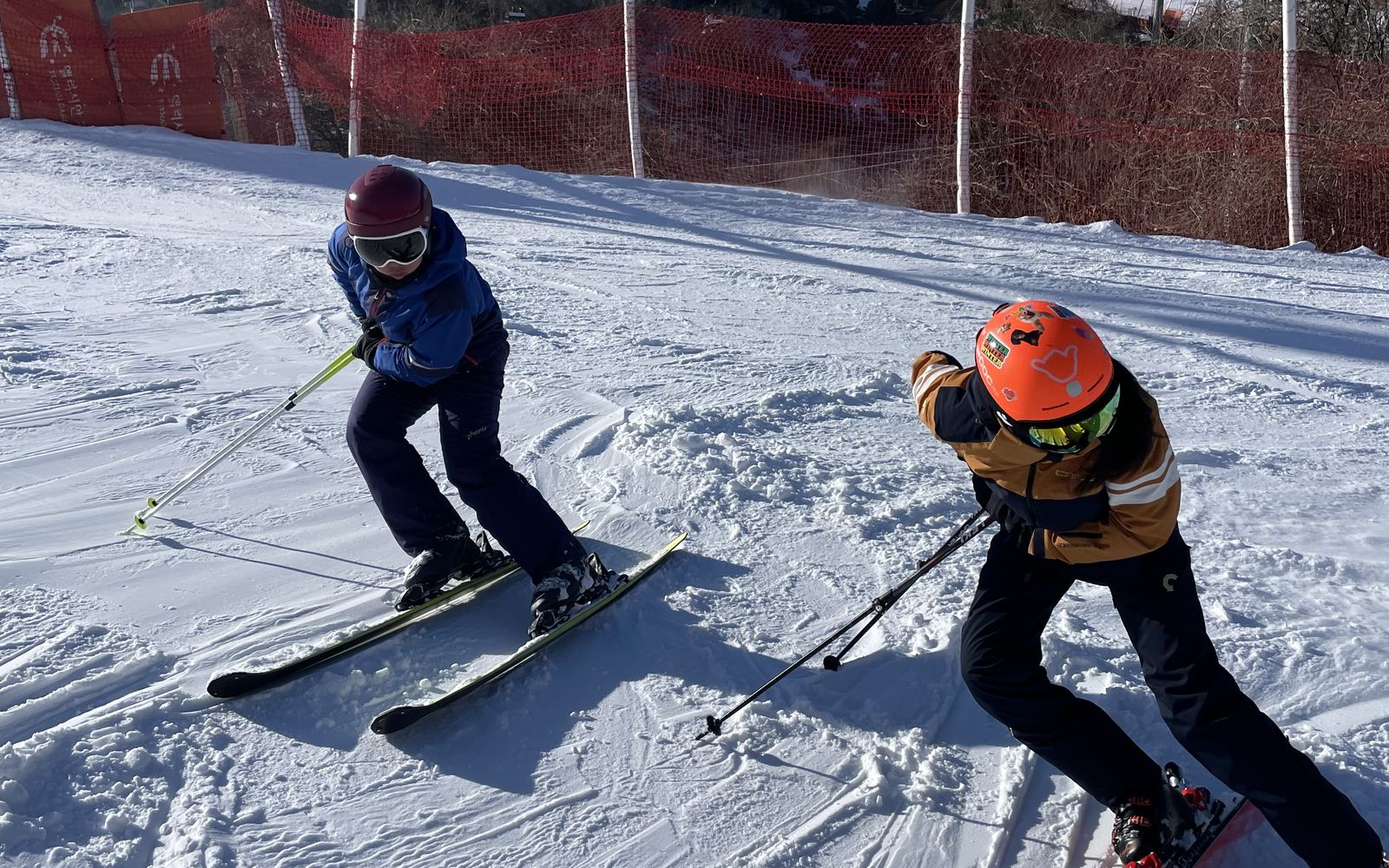 An instructor coaching a child one-on-one on the slope
