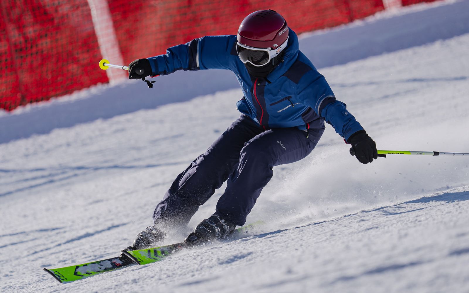 A junior skier carving a turn down the slope